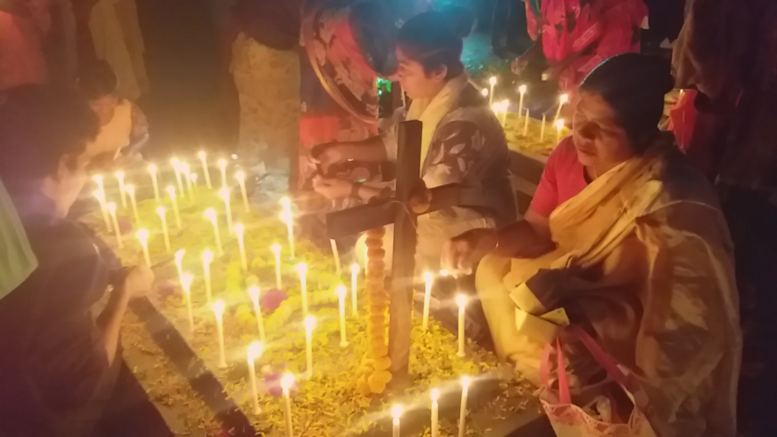 পাঁচবিবিতে প্রিয়জনের সমাধির পাশে মোমবাতি জ্বালিয়ে নিরবে প্রার্থনা করছেন স্বজনেরা